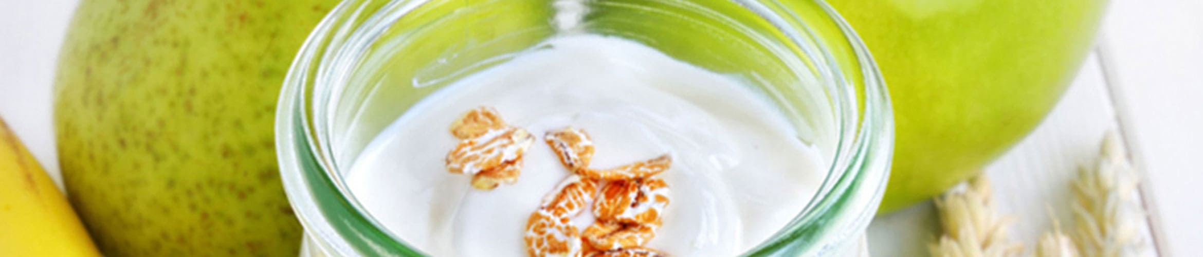 Ernährungsmedizin Bild mit grünen Äpfel und Birnen sowie eine Glasschüssel Müssli.