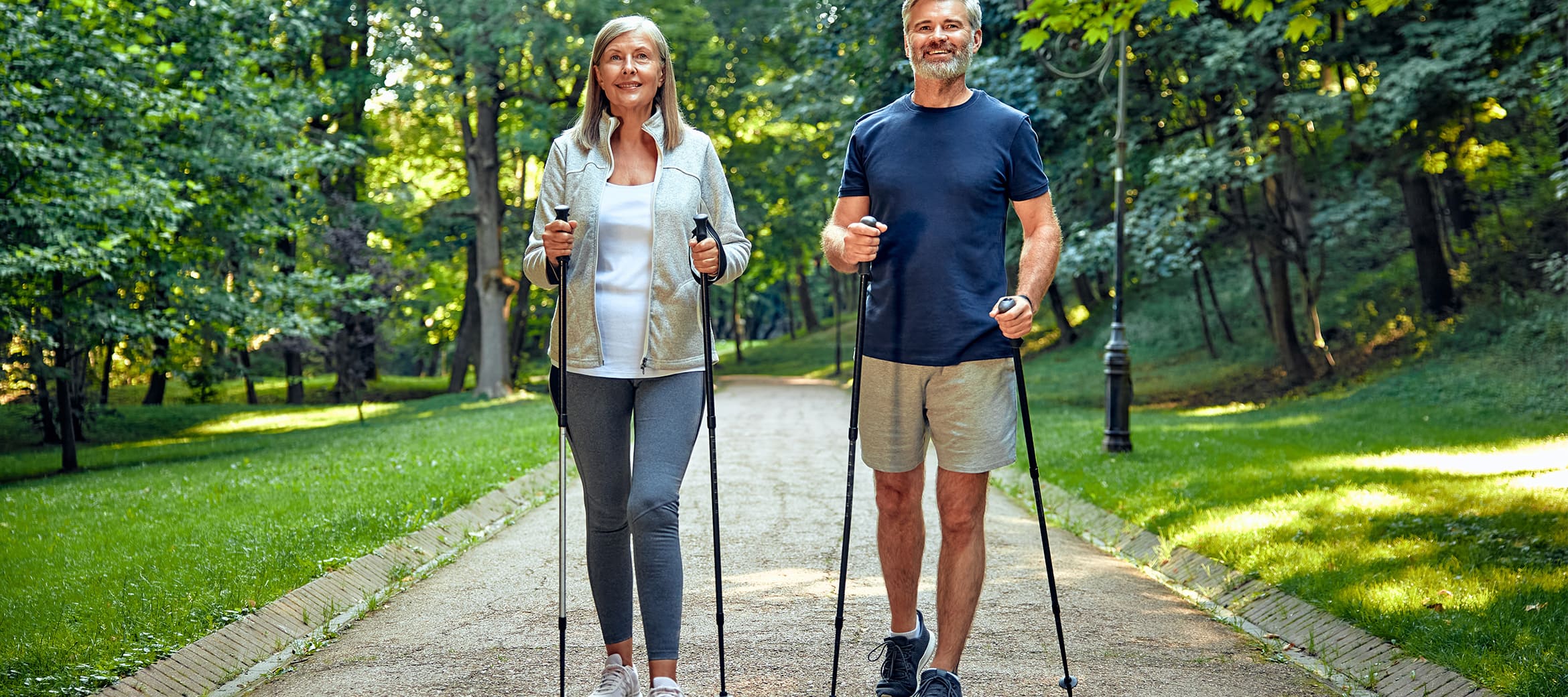 Darstellung "Japanisches Gehen" 10.000 Schritte pro Tag Ehepaar läuft mit Wanderstöcken im Park